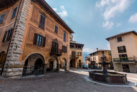 piazza con casa storica e fontana ottagonale a Borno Altopiano del Sole