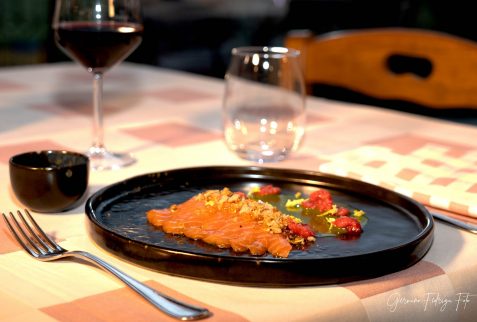 piatto di salmerino condito e calice di vino rosso del ristorante al resu di Lozio altopiano del sole