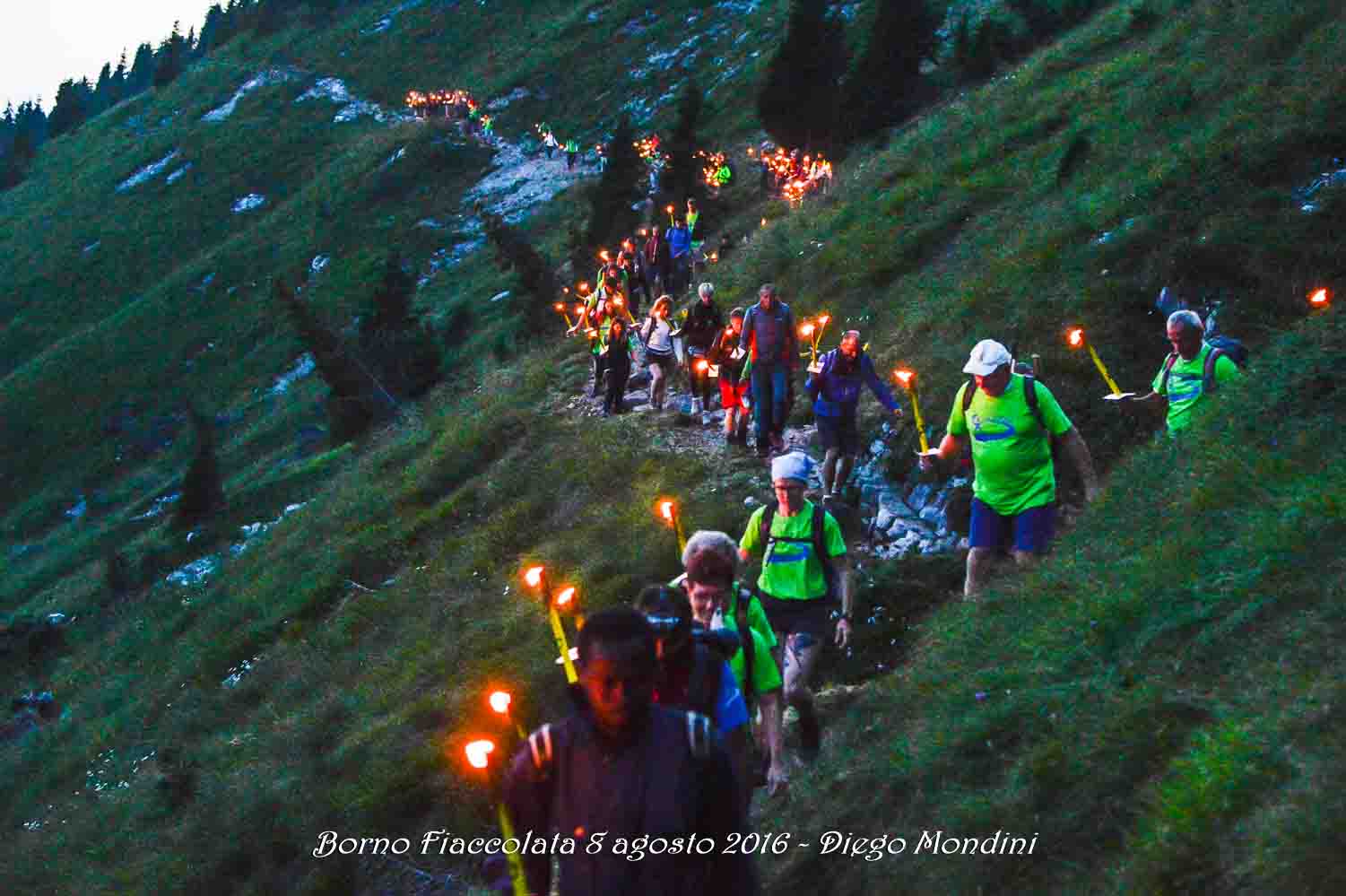 camminatori sul sentiero che scende in piazza a Borno da San Fermo in occasione della fiaccolata